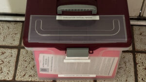 A portable plastic file box labeled "EVACUATION: CRITICAL PAPERS"